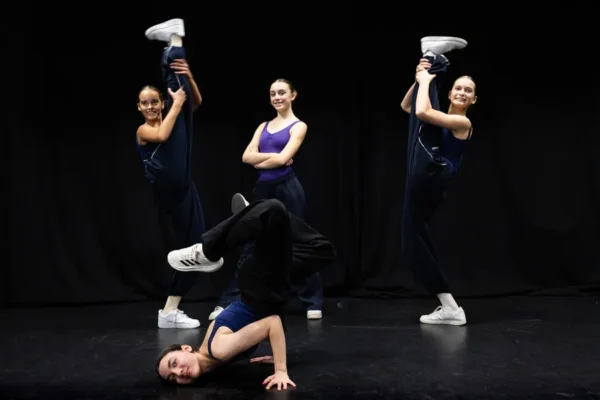 Teen dancers holding an acro group balance on stage