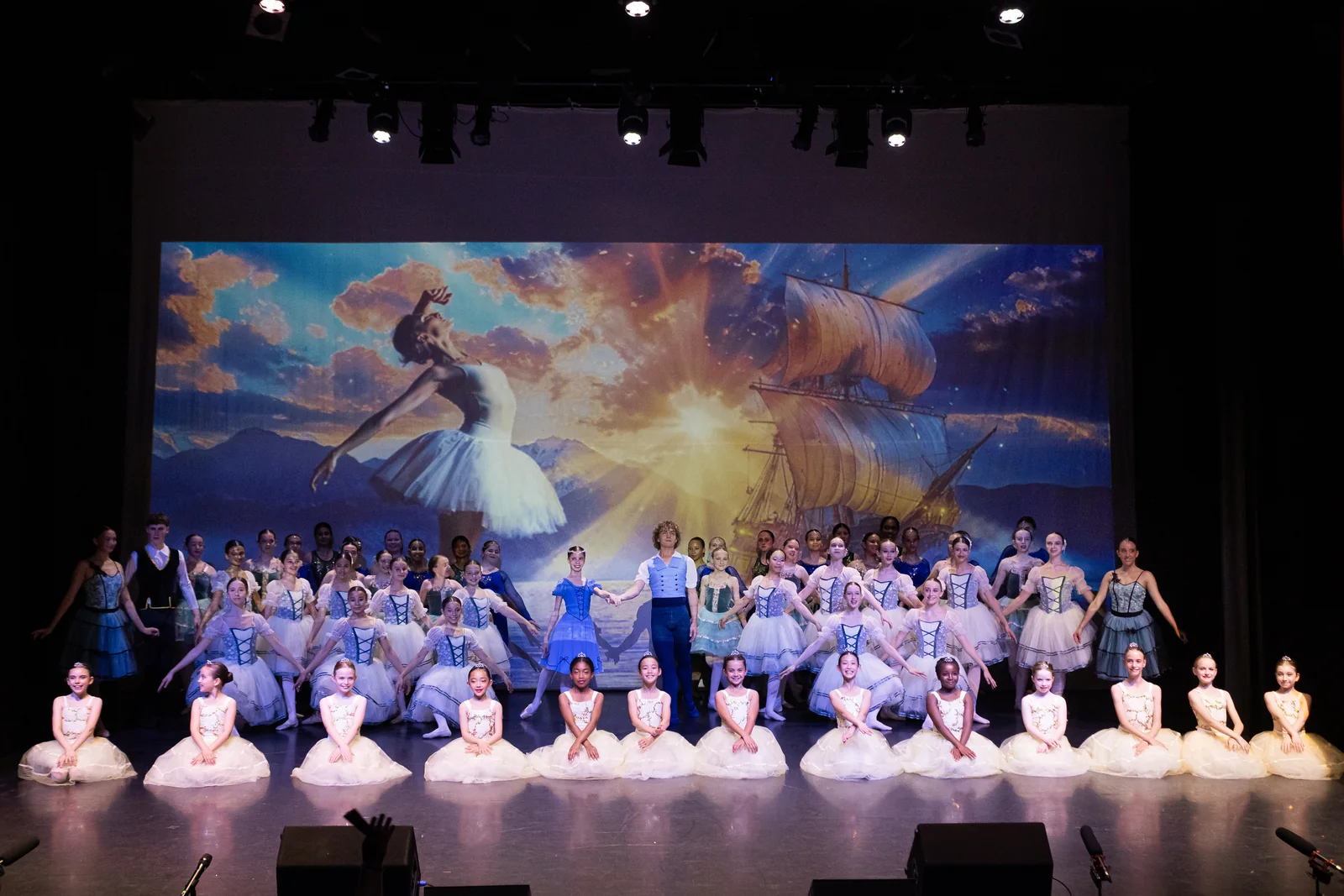 SA Dance students in blue and cream tutus performing together on stage at the annual show